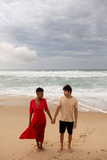 海の近くのビーチで愛情を示すロマンチックなカップル
