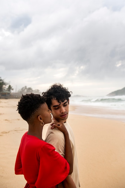 Romantic couple showing affection on the beach near the ocean