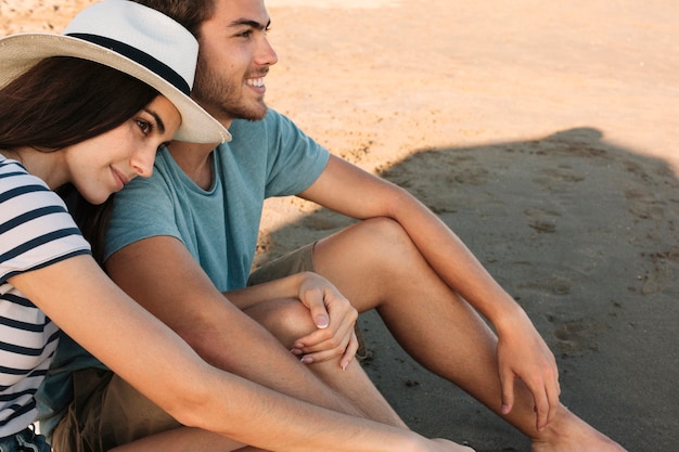 Free photo romantic couple sitting at the beach