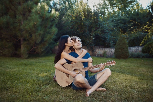 Romantic couple sitting on the grass in the garden