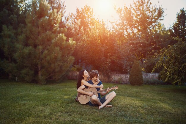 庭の芝生の上に座ってロマンチックなカップル