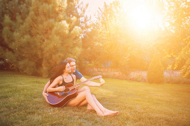 Romantic couple sitting on the grass in the garden