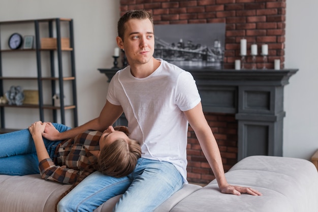 Romantic couple sitting and lying on sofa 