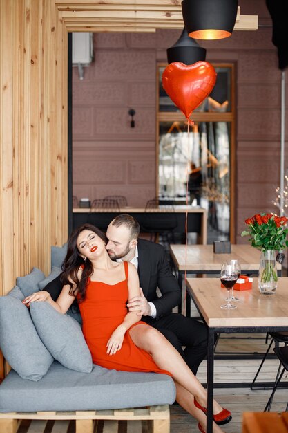 Romantic couple sitting in restaurant on a date and hugging