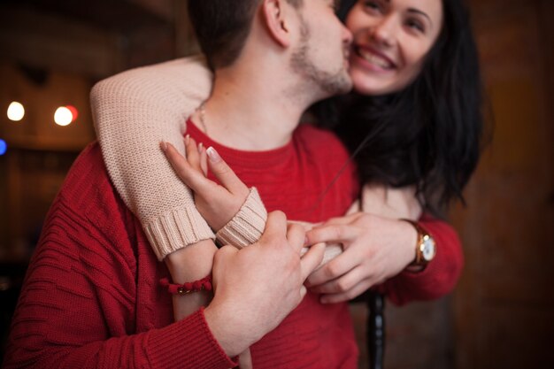 "Romantic couple in sweaters embracing"