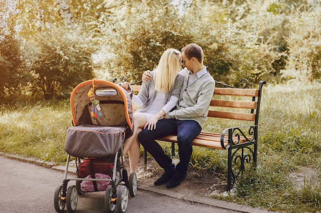 Romantic couple with stroller on a park bench