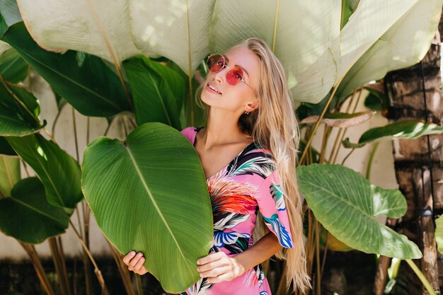 Romantic girl in bright stylish attire enjoying photoshoot on nature background.