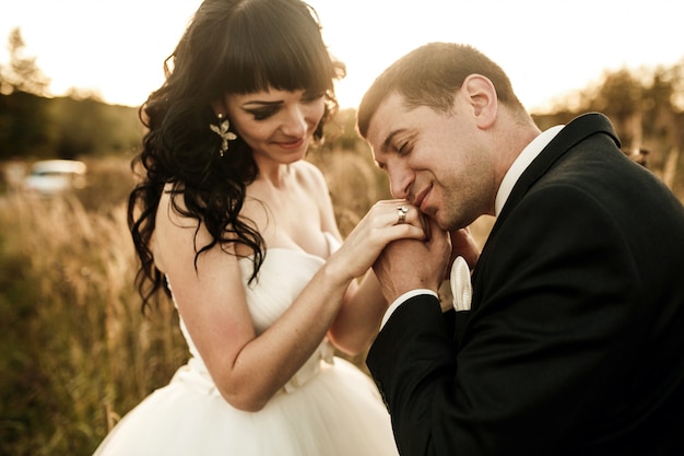 Free photo romantic groom holding his wife's hands