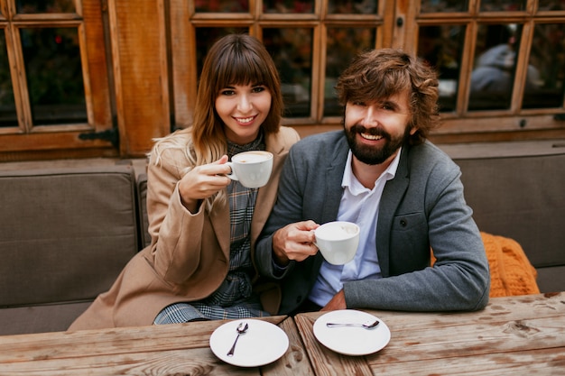 カフェに座って、コーヒーを飲みながら、会話をしながら、お互いに過ごす時間を楽しんでいる優雅なカップルのロマンチックな瞬間。