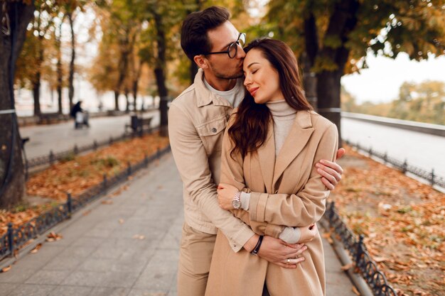 ロマンチックな瞬間。恋に浮気し、素晴らしい秋の公園で楽しんで幸せな美しいカップル。
