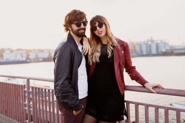 Romantic moments of stylish couple in love having a conversation and enjoying the time spend with each other . Handsome man with his wife walking on the bridge.