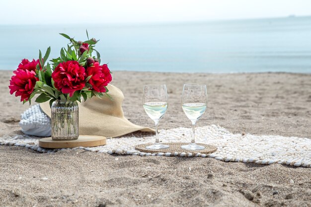 Romantic picnic with flowers and glasses of champagne by the sea. The concept of a holiday.