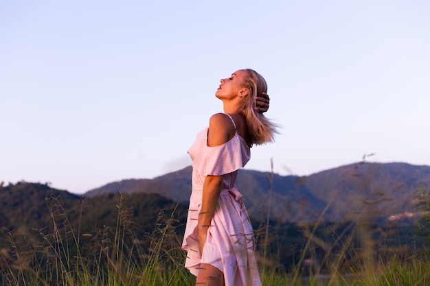 Romantic portrait of young caucasian woman in summer dress enjoying relaxing in park on mountain with amazing tropical sea view Female on vacation travel around Thailand Happy woman at sunset