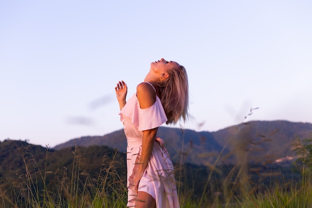 Romantic portrait of young caucasian woman in summer dress enjoying relaxing in park on mountain with amazing tropical sea view Female on vacation travel around Thailand Happy woman at sunset