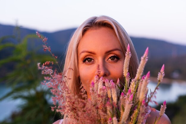 Romantic portrait of young caucasian woman in summer dress enjoying relaxing in park on mountain with amazing tropical sea view