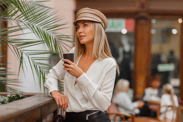 Romantic  pretty  blond woman enjoying hot coffee outdoor