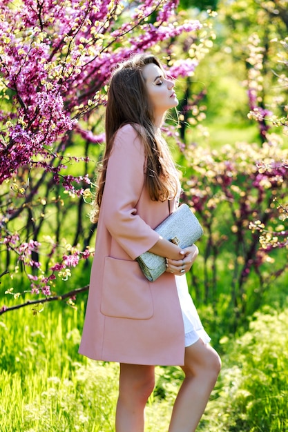 Romantic pretty young woman with long hair in pink coat