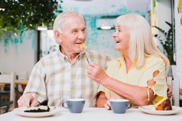 Romantic senior couple enjoying dessert in cafe