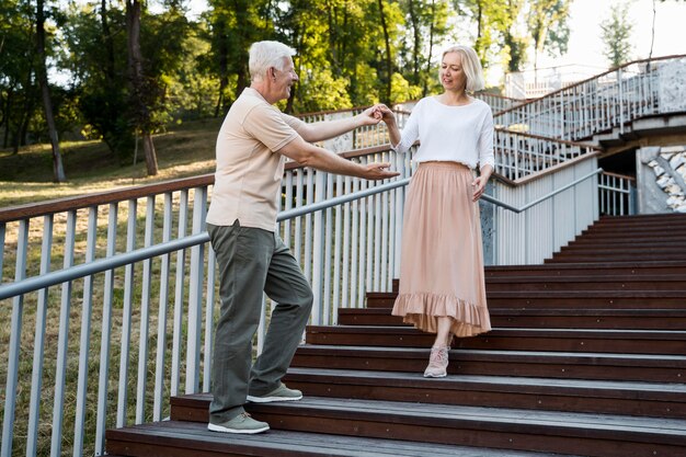 ステップで屋外で一緒にポーズロマンチックな年配のカップル