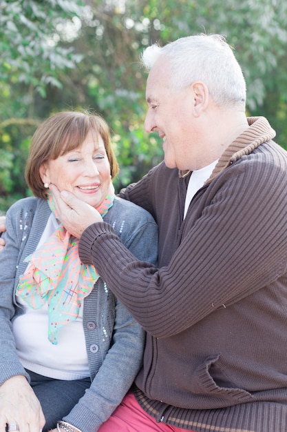 Free photo romantic senior man touching his wife's cheek