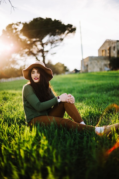 Romantic stylish woman sitting on lawn