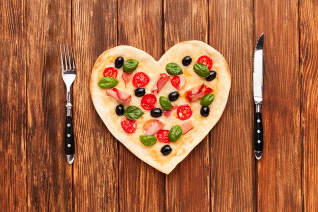 Romantic table setting with pizza and tableware