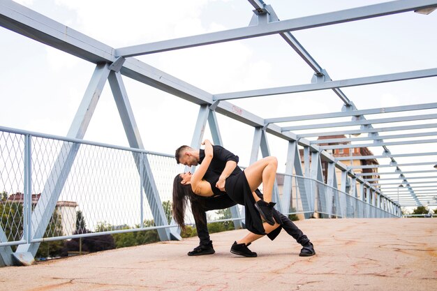 Romantic tango dancing couple performing on bridge