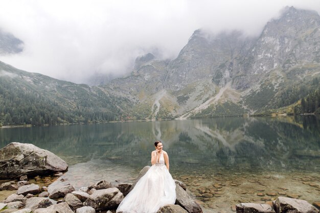 ポーランドのシーアイ湖の愛立っているロマンチックな結婚式のカップル。タトラ山脈。