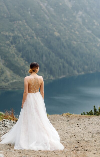 Romantic wedding couple in love standing of the Sea Eye lake in Poland. Tatra mountains.