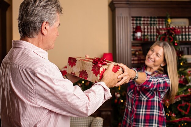 Romantic woman giving a present to her husband