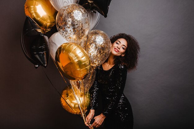 Romantic woman holding bunch of party balloons