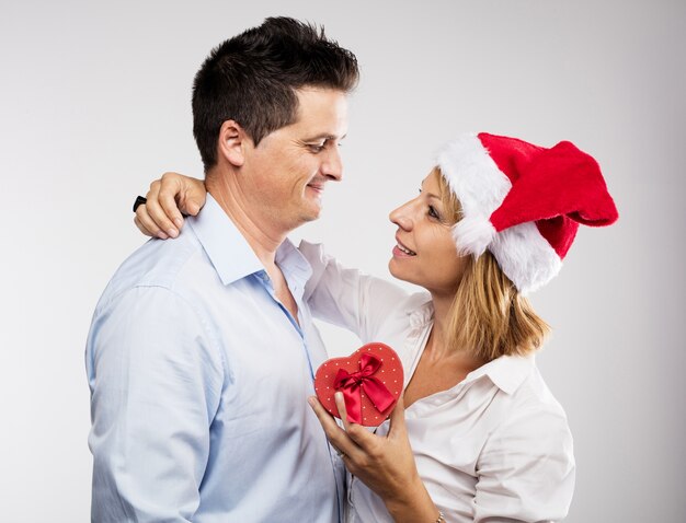 Romantic woman holding a present next to her husband