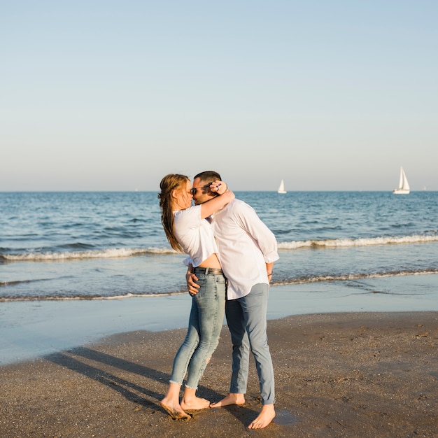 해변에서 여름 휴가를 즐기는 로맨틱 젊은 부부