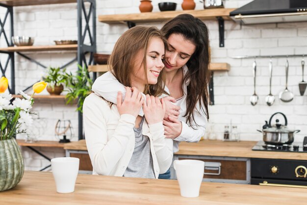 2つのコーヒーカップと木製のテーブルの前でロマンチックな若いカップル