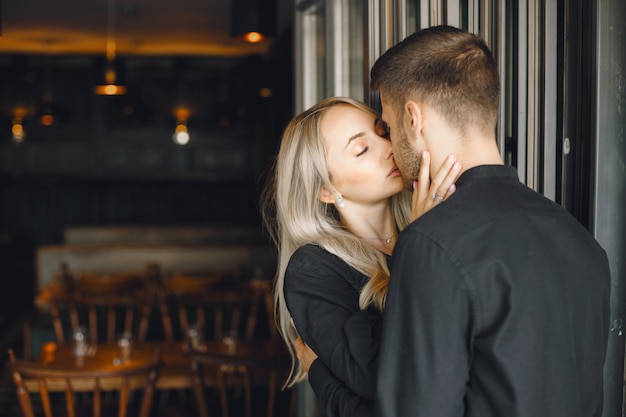 Romantic young couple hugging at cafe window