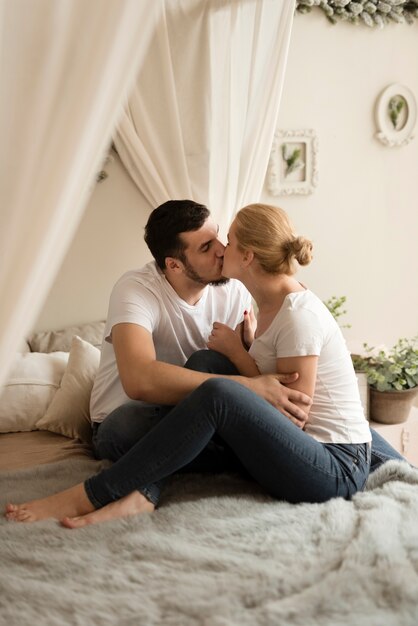 ロマンチックな若いカップルが自宅でキス