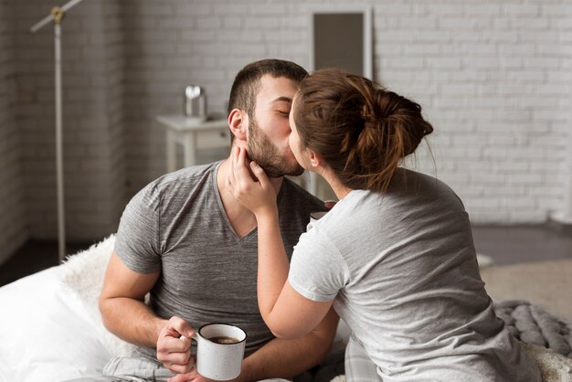 Romantic young couple kissing indoors