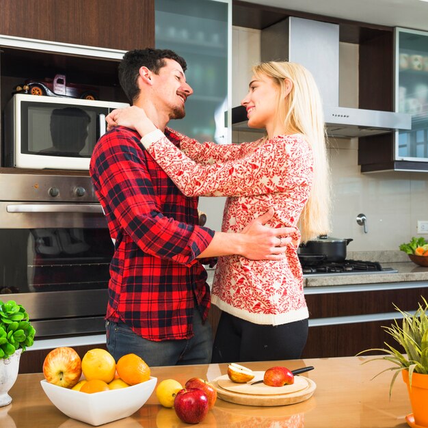 Романтическая молодая пара, глядя друг на друга на кухне