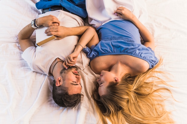 Romantic young couple lying on bedroom