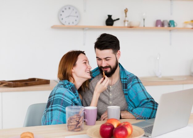 Romantic young couple wearing a warm blanket