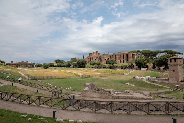 로마, 이탈리아 - 2018년 6월 23일: 고대 로마의 팔라티노 언덕에 있는 아폴로 팔라티누스 신전의 탁 트인 전망과 서커스 막시무스(circo massimo)는 고대 로마 경주 경기장이자 대규모 엔터테인먼트입니다.