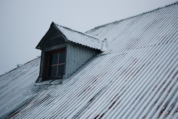 Roof of the building covered in snow against the cloudy sky