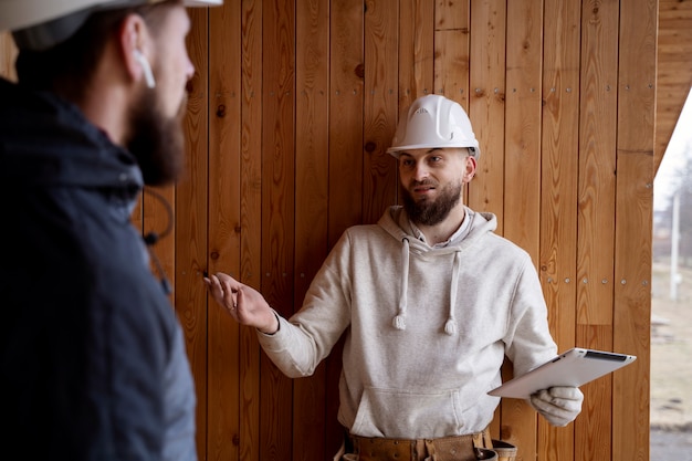 Foto gratuita roofers con caschi che lavorano insieme