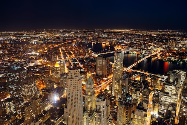 Rooftop night view of New York City downtown with urban skyscrapers