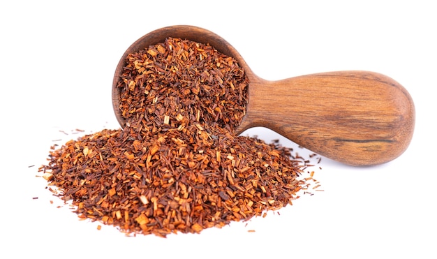 Красный чай ройбуш в деревянной ложке на белом фоне традиционный травяной и органический чай
