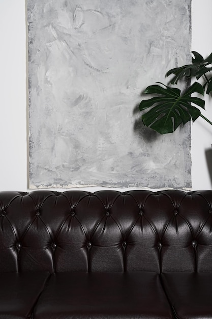 Бесплатное фото Детали интерьера комнаты с удобным креслом серым гобеленом на вертикальной раме стены
