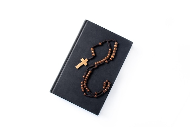 Rosary catholic cross on holy bible isolated on white background