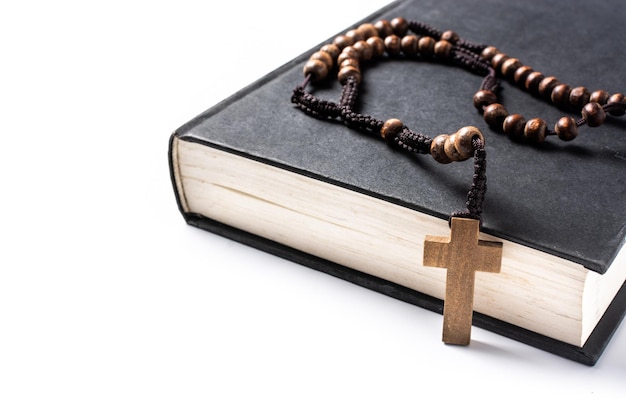 Rosary catholic cross on Holy Bible isolated on white background