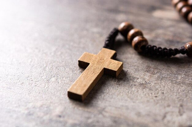 木製のテーブルの上のロザリオカトリックの十字架