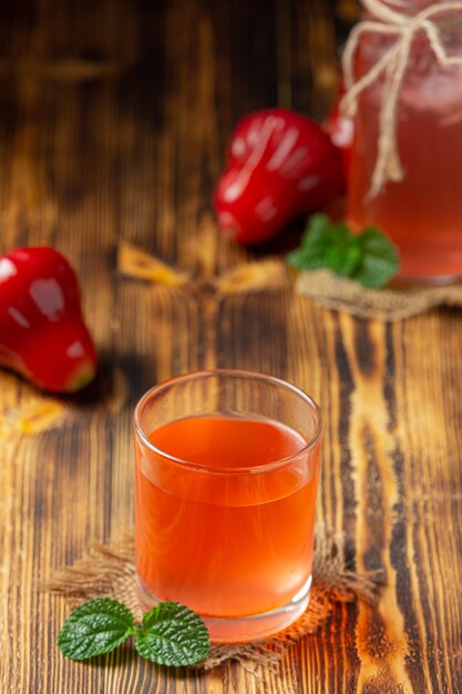 Rose apple juice on dark wooden surface